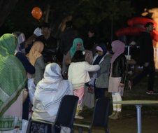 A group of people are standing around a table at a party.