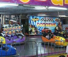 People are riding bumper cars under a sign that says dodge gems