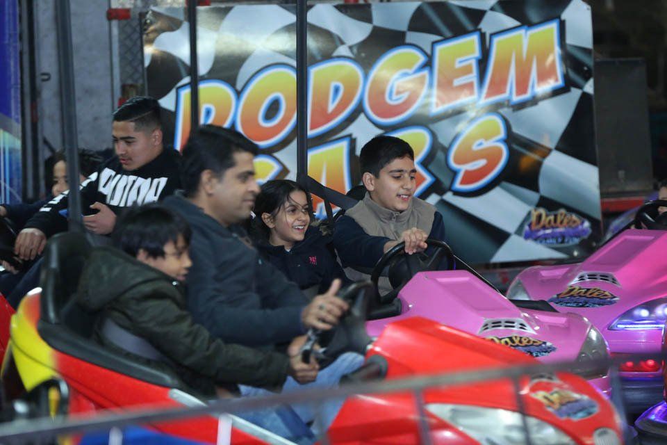 A group of people are riding a ride called dodgem cars