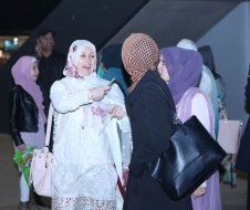 A group of women in hijab are standing next to each other and talking.