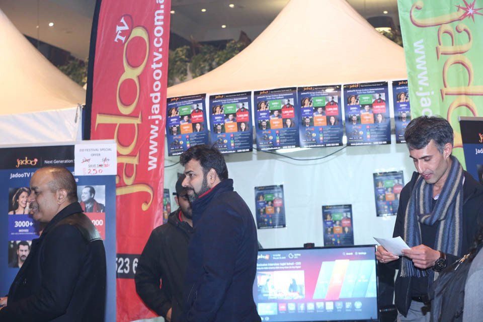 A group of men standing in front of a banner that says jadootv.com