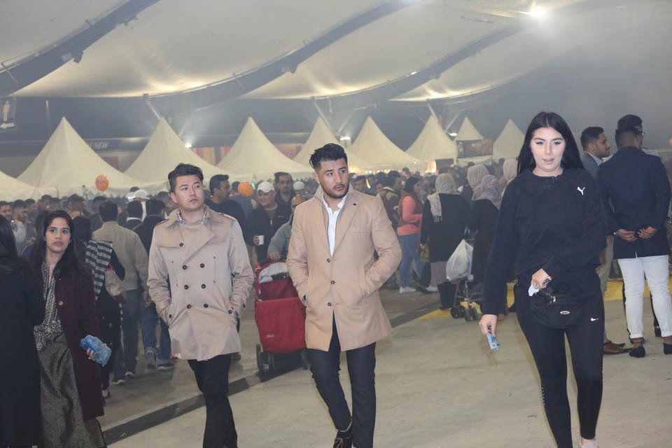 A group of people are walking in a crowded area.