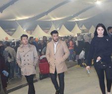 A group of people are walking in a crowded room.