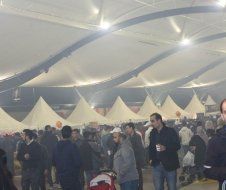 A large group of people are standing under a tent.