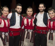 A group of people in traditional costumes are posing for a picture.
