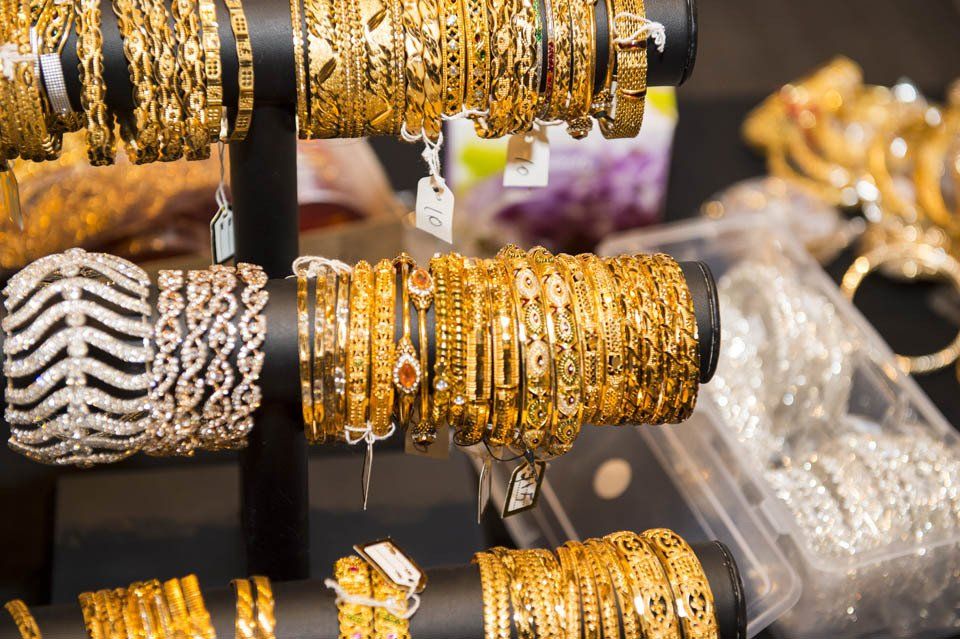 A display of gold and silver bracelets on a stand