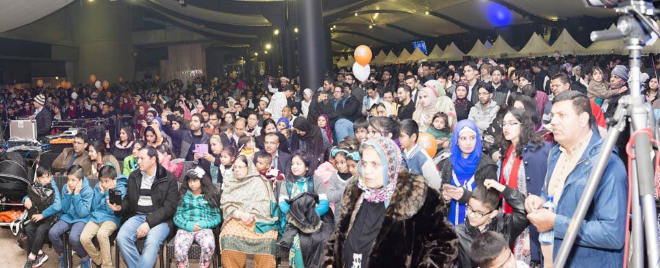 A large group of people are sitting in a large room.