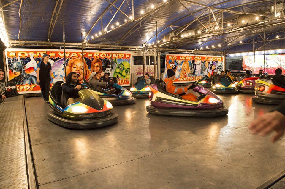 A group of people are riding bumper cars at a carnival.
