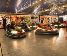 A group of people are riding bumper cars at an amusement park.