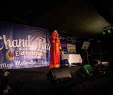 A woman is standing on a stage holding a microphone.