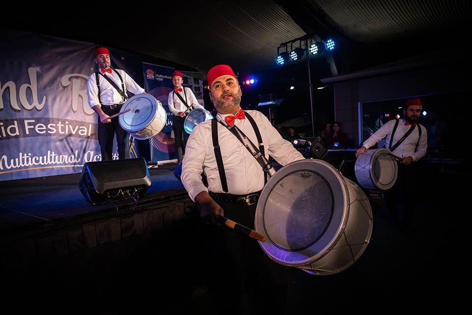A group of men are playing drums on a stage.