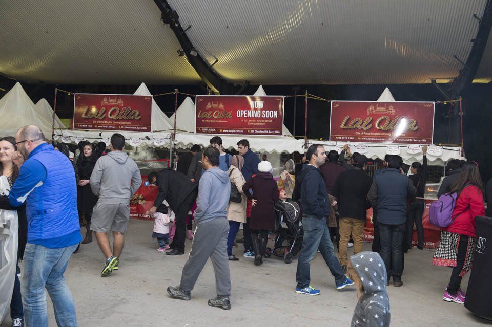 A group of people are standing in a tent at a food festival.