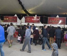 A group of people are standing under a tent.