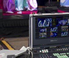 A laptop is sitting on top of a table next to a remote control.