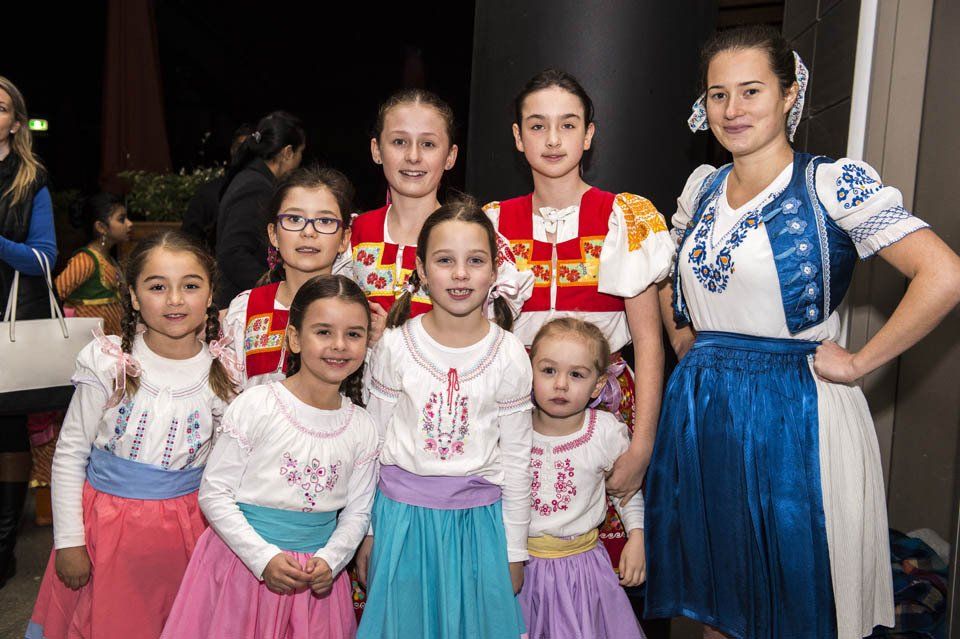 A group of young girls in traditional costume are posing for a picture.