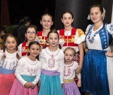 A group of young girls in traditional costumes are posing for a picture.
