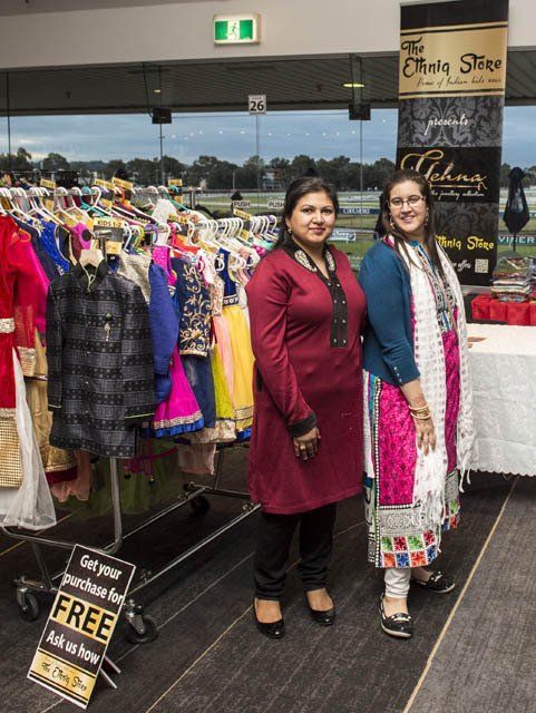 Two women standing next to each other in front of a sign that says free