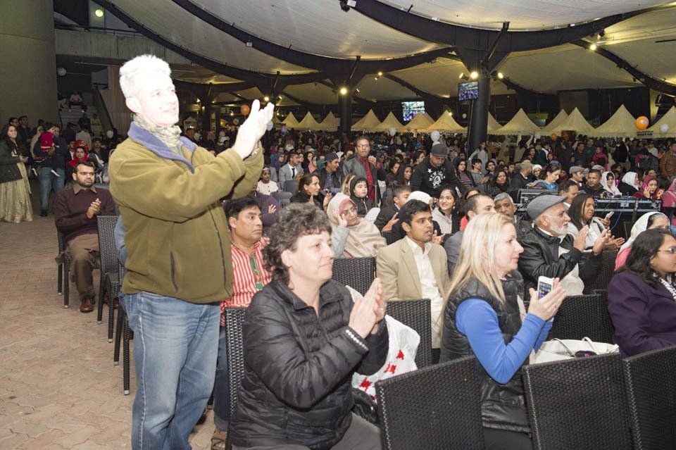 A group of people are sitting in a room and applauding