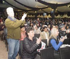 A group of people are sitting in chairs in a room applauding.