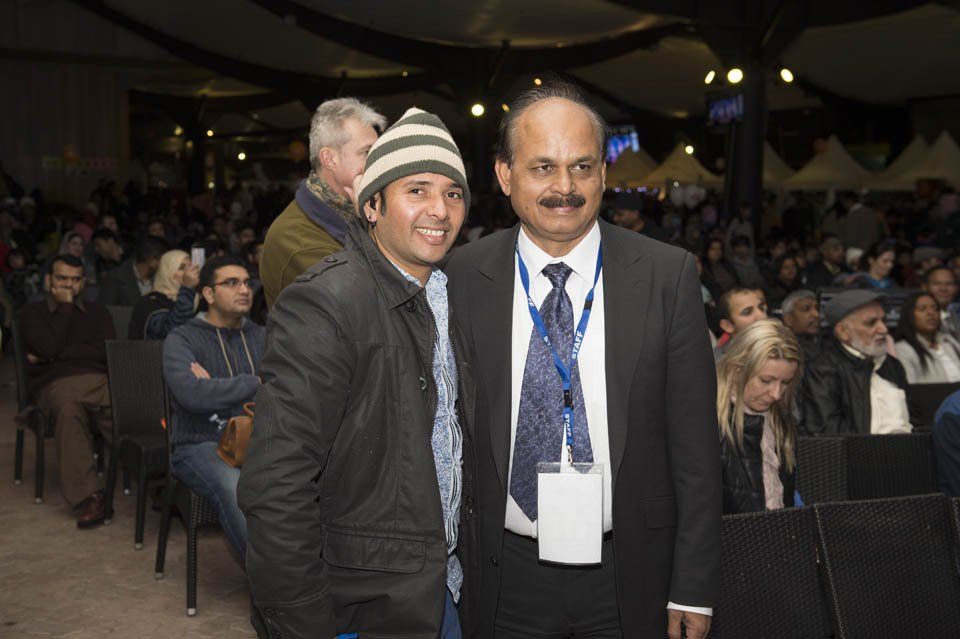 Two men posing for a picture in front of a crowd
