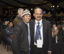 Two men are posing for a picture in front of a crowd.