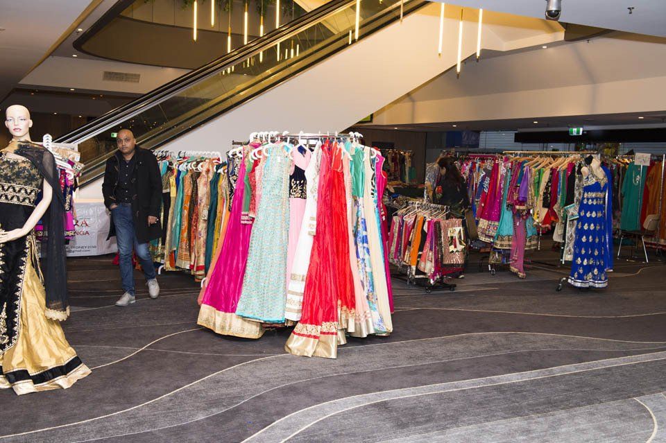A mannequin is standing in front of a display of clothes in a store