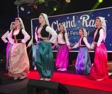 A group of women are dancing on a stage in front of a sign.