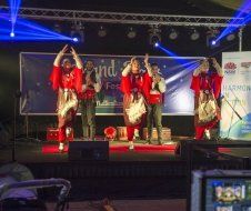 A group of people are dancing on a stage at a concert.