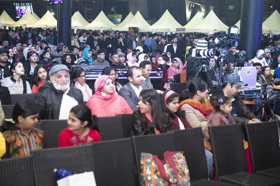 A large group of people are sitting in rows at a concert.