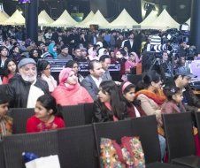 A large group of people are sitting in chairs at a concert.