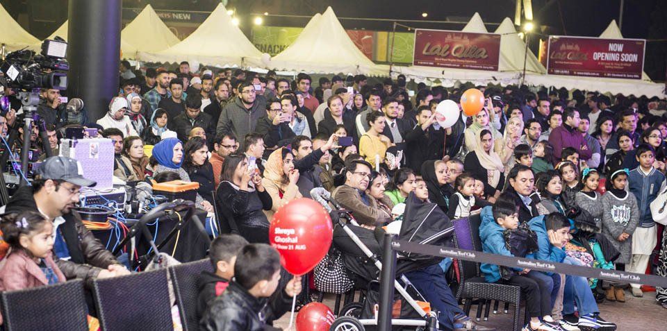 A large crowd of people are sitting in chairs at a concert.