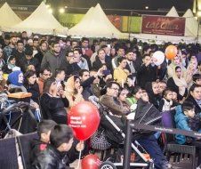 A large group of people are sitting in chairs at a festival.