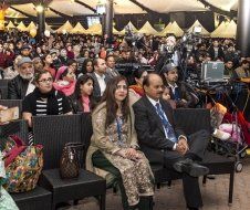 A large group of people are sitting in chairs in a room.
