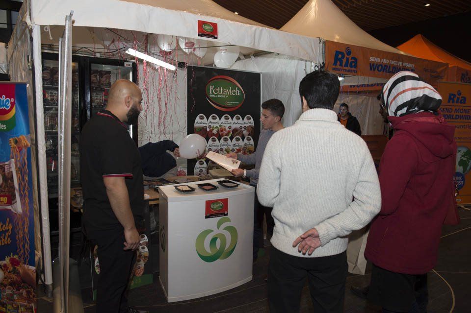 A group of people standing in front of a booth that says rio
