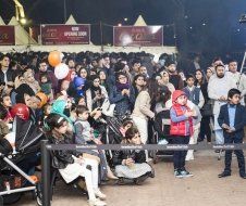 A large group of people are sitting in a stadium watching a concert.
