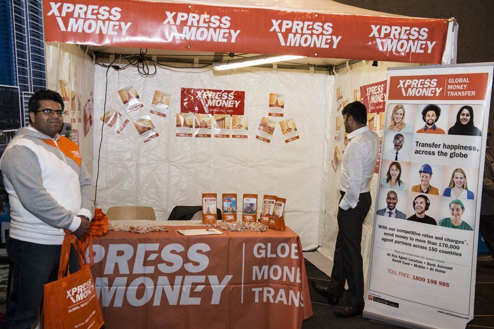 A man standing in front of a xpress money booth