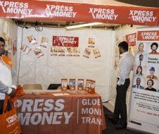 A man standing in front of a table that says xpress money