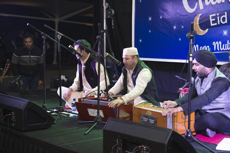 A group of men are playing musical instruments on a stage.