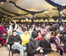 A large group of people are sitting in chairs in a large room.