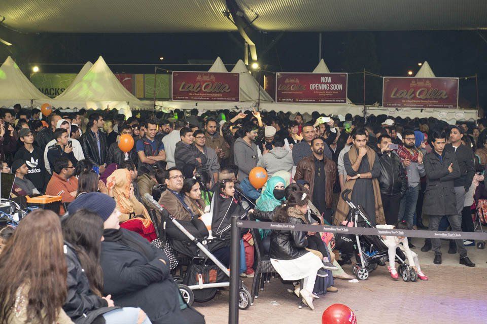 A large crowd of people are gathered at a bowling alley.