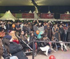 A crowd of people are gathered under a tent at a festival.