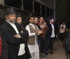 A group of men are standing next to each other in a room.