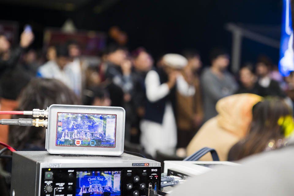 A camera is sitting on a table in front of a crowd of people.