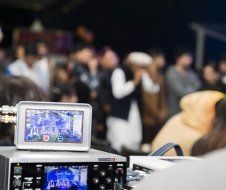 A camera is sitting in front of a crowd of people.