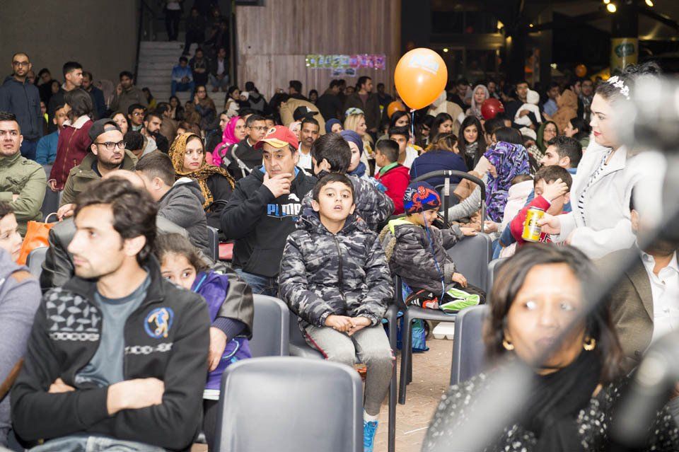 A large group of people are sitting in a theater watching a show.