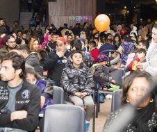 A large group of people are sitting in chairs in a room.