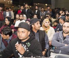 A group of people are sitting in a room watching a presentation.