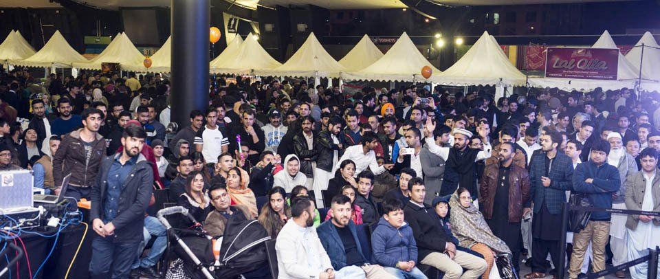 A large crowd of people are gathered at a festival.