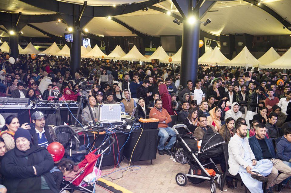 A large crowd of people are gathered in a large room
