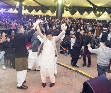 A group of men are dancing in front of a crowd at a party.